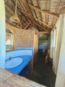 a bathroom with a tub and a brick wall at Hôtel Safari Vezo Anakao in Anakao