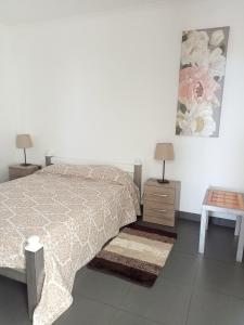 a white bedroom with a bed and two night stands at Casa da Bella in Velas