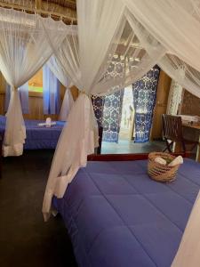 a bedroom with a bed with a canopy at Hôtel Safari Vezo Anakao in Anakao