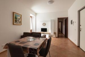 a living room with a table and chairs and a television at Sotto La Torre in LʼAquila