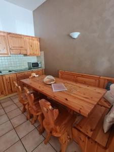 a wooden table in a kitchen with wooden chairs at Appartamento El Feudo in Tesero +23 photos