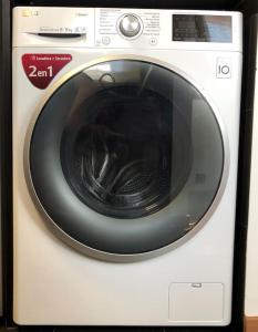 a white washing machine with a black door at Acogedor apartamento en pleno centro in Puigcerdà