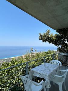 a table and chairs on a balcony with the ocean at Vila Jona Palasë in Dhërmi