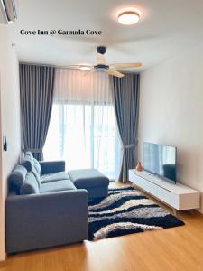a living room with a couch and a tv at Mayabay Residences - Cove Inn in Pulau Kempas