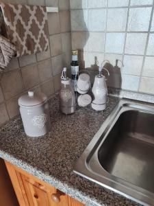 a kitchen counter with three crock pots and a sink at Appartamento El Feudo in Tesero