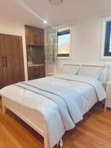 シドニーにあるRyde guest houseの窓付きのベッドルームの大きな白いベッド