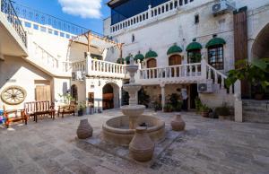 a courtyard with a fountain in the middle of a building at Nomad inn in Sanlıurfa
