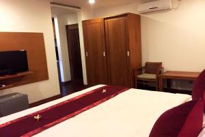 a bedroom with a bed and a tv and a desk at Delu Villas & Suite in Kerobokan