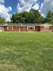 a large brick house with a large grass field at University Cozy Escape in Huntsville