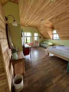 a living room with a bed and a wooden ceiling at Warmińska Sielanka in Blanki