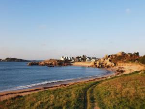 a beach with some rocks in the water at Villa lumineuse 4 étoiles, 50m de la plage, jardin clos, tranquillité à Trégastel - FR-1-368-399 in Trégastel