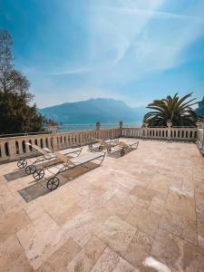 a row of benches sitting on a patio overlooking the ocean at Bellavista Lakefront Apartments in Riva del Garda +47 photos