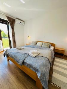a bedroom with a large bed with towels on it at B&B Plitvica Falls House in Plitvica selo