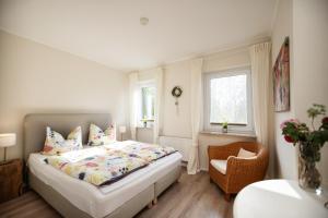 a small bedroom with a bed and a chair at Immenhagen Ferienwohnungen in Malente