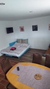 ein Zimmer mit einem Bett, einem Tisch und Stühlen in der Unterkunft Bobnarica in Grahovo