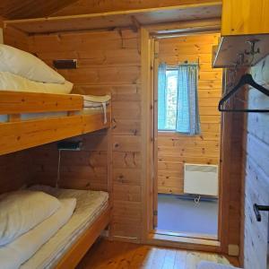 a bedroom with two bunk beds and a window at Lensmansgarden in Innfjorden +9 photos