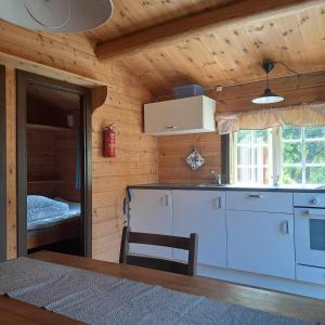 a kitchen in a log cabin with a bed at Lensmansgarden in Innfjorden