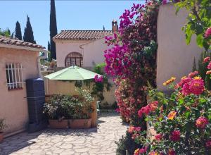 an outdoor patio with flowers and an umbrella at Les Loulous in Ceyreste