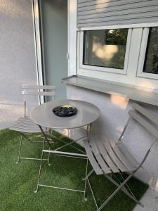 a table and a chair sitting next to a window at Apartments Mitte Messe und Zentrum Heistersteg in Nürnberg +2 photos