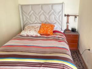 een bed met twee oranje kussens erop bij Casa Manzanapata in Cuzco