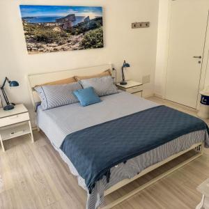 Un dormitorio con una cama grande con dos mesitas de noche. en Alegria Alghero, en Alghero