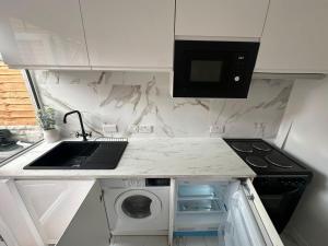 a kitchen with a sink and a washing machine at The White House in Birmingham