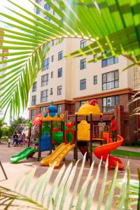 a playground in front of a large building at Greyscape Apple Tree Apartment in Nairobi