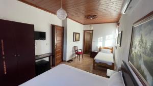 1 dormitorio con 1 cama, escritorio y 1 habitación en Denis GuestHouse 1930, en Gjirokastra