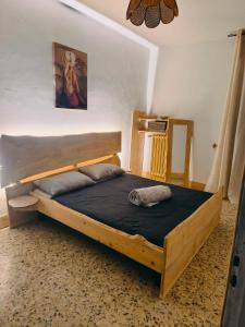 una camera da letto con un letto di legno in una stanza di Casa Regis a San Giacomo