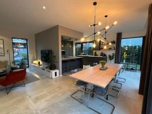 a large living room with a wooden table and chairs at Large pool villa, roof terrace near lake & nature in Floda