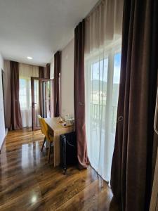 a dining room with a table and a large window at B&B House in Mestia +107 photos