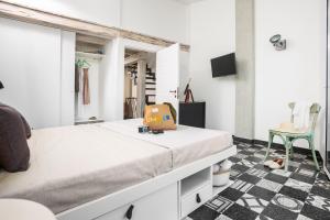 a white room with a bed and a chair at Lu Gamasinu di Ziu Vittorio in Santa Teresa Gallura
