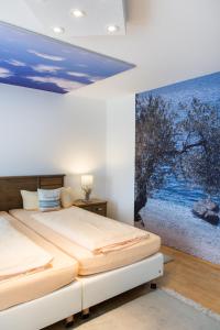バート・ヘルスフェルトにあるホテルペンション ビタリスのベッドルーム1室(ベッド1台付)が備わります。壁には絵画が飾られています。