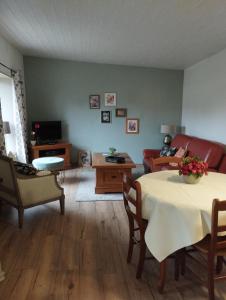 a living room with a table and a couch at Le gîte du courtil in Tressé