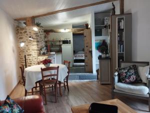 a living room with a table and a kitchen at Le gîte du courtil in Tressé +19 photos
