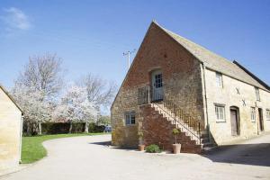 a brick building with a staircase on the side of it at Boddingtons Barn @ Norton Grounds in Chipping Campden