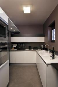 a kitchen with white cabinets and a sink at The Stone Villa in Beli Iskar