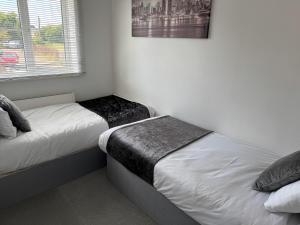 two beds in a small room with white walls at Stony Apartment House in Doncaster