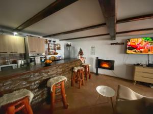 a kitchen with a bar with stools and a fireplace at Chalet Motilor Straja in Lupeni