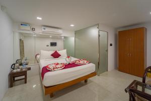a bedroom with a bed with red pillows on it at Nathan Resort with Swimming Pool in Puducherry