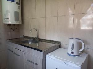 Una pequeña cocina con fregadero y lavadora. en Cabaña del Lago, en San Carlos de Bariloche 3 fotos más