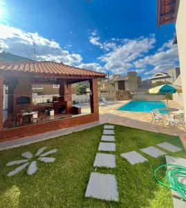 Un patio trasero con piscina y una casa. en Casa no Centro de Águas de Lindóia com Piscina, en Águas de Lindóia