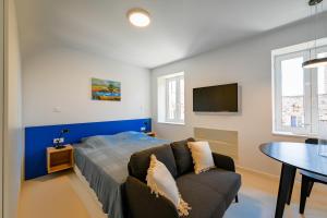 a bedroom with a bed and a couch and a table at House Grisia 33 in Rovinj