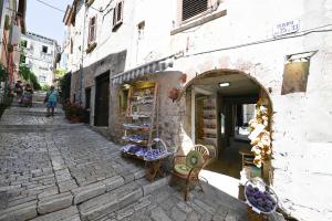 a shop on a cobblestone street next to a building at House Grisia 33 in Rovinj