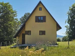 une grande maison jaune avec un toit de chaume dans l'établissement Enchanting chalet amidst impressive nature, à Žabljak