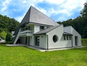 a large white house with a gambrel roof at Villa avec piscine, Cinéma, terrain privé in Nogent-le-Phaye
