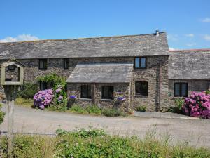an old stone house with flowers in front of it at West Lee in Bude