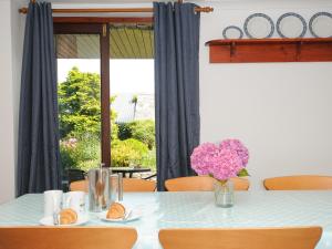 a table with a vase of flowers and a window at West Lee in Bude +24 photos