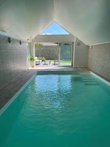 a swimming pool with blue water in a house at Villa de standing en Champagne in Fresnes-lès-Reims