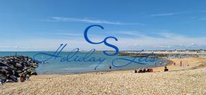 ein Blick auf einen Strand mit den Worten „Feiern Sie das Leben“ in der Unterkunft Sea View Lodge, Seal Bay Resort, Selsey in Selsey